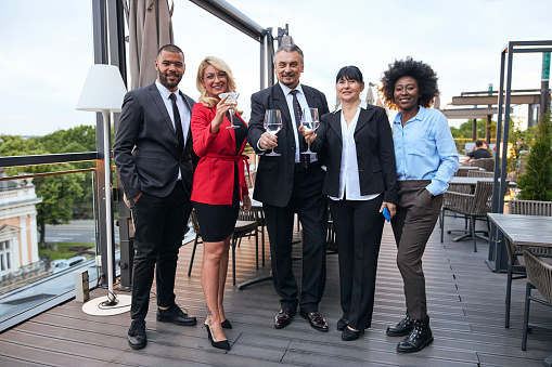 A diverse multi-ethnic group of business people on a social gathering on balcony.