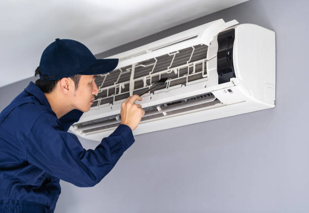 istock technician service using brush to cleaning the air conditioner 1255408044