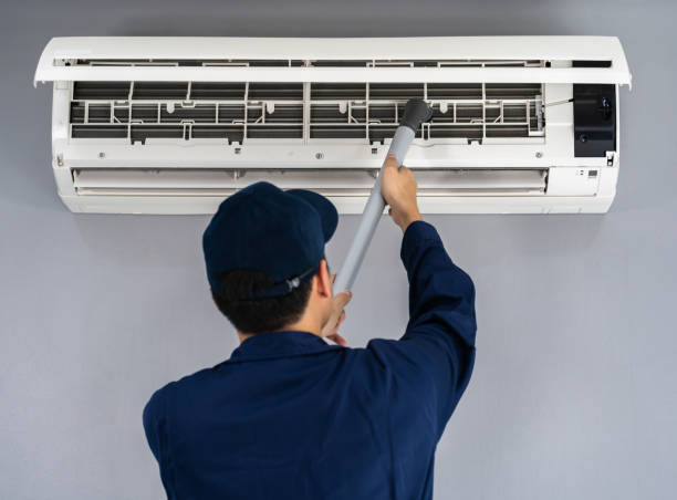 istock technician service using vacuum cleaner to cleaning air conditioner 1255408068