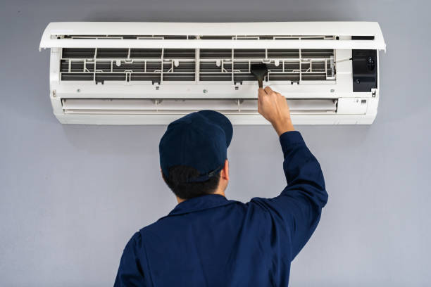 istock technician service using brush to cleaning the air conditioner 1255408077