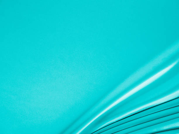 istock Beautiful elegant wavy turquoise silk or satin luxury cloth fabric texture, abstract background design. 1255410467