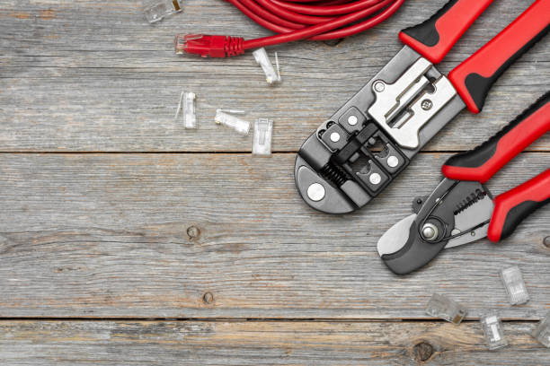 istock Crimping tools and wires with connectors on a gray wooden table. Tools for connecting the Internet 1255411687