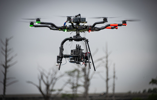 A digital cinema camera is affixed to a heavy duty drone.