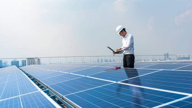 elektroingenieure verwenden laptops, um den betrieb des solardachs zu überwachen. erneuerbare-energien-konzepte. - blue helmet stock-fotos und bilder