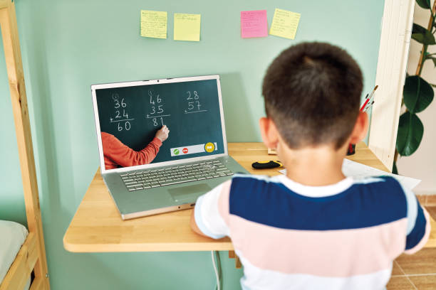 istock 6-7 years cute child learning mathematics from computer. Homeschooling 1255417063