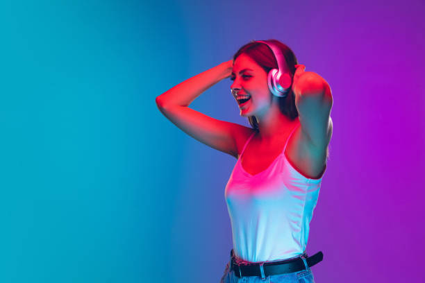 istock Caucasian young woman's portrait isolated on gradient purple-blue background in neon light 1255417127