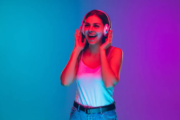 istock Caucasian young woman's portrait isolated on gradient purple-blue background in neon light 1255417128