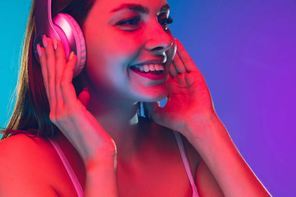 istock Caucasian young woman's portrait isolated on gradient purple-blue background in neon light 1255417129