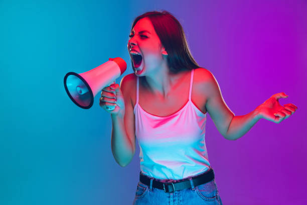 istock Caucasian young woman's portrait isolated on gradient purple-blue background in neon light, cinema, movie watching 1255417166