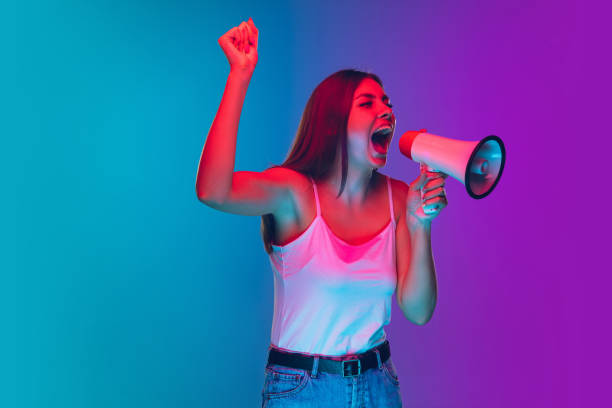 istock Caucasian young woman's portrait isolated on gradient purple-blue background in neon light, cinema, movie watching 1255417171