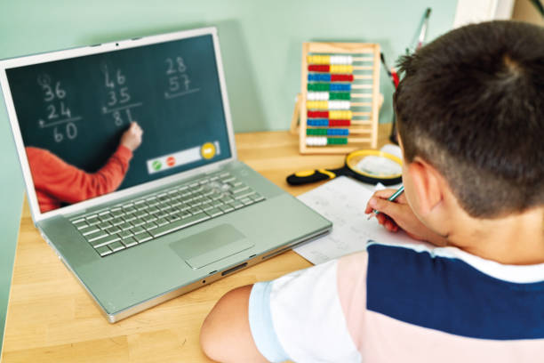 istock 6-7 years cute child learning mathematics from computer. Homeschooling 1255417530