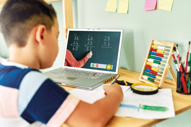 istock 6-7 years cute child learning mathematics from computer. Homeschooling 1255417646