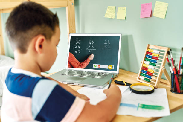 istock 6-7 years cute child learning mathematics from computer. Homeschooling 1255418601