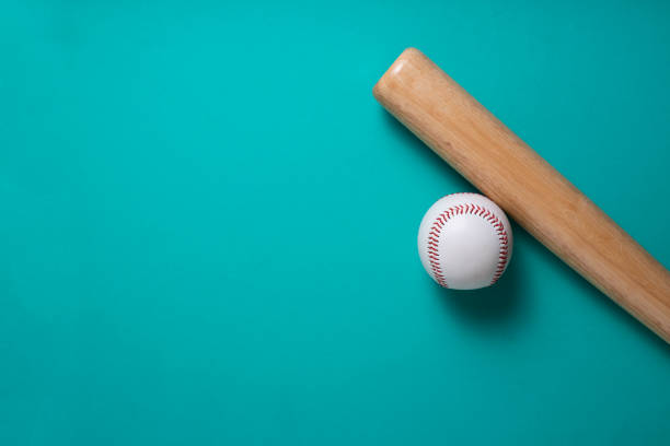 istock baseball and baseball bat on green table background, close up 1255418946