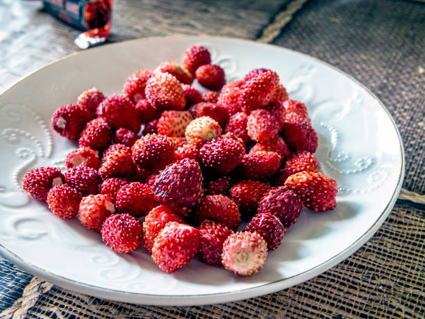 istock fresh ripe red strawberries on a white saucer, macro 1255421620
