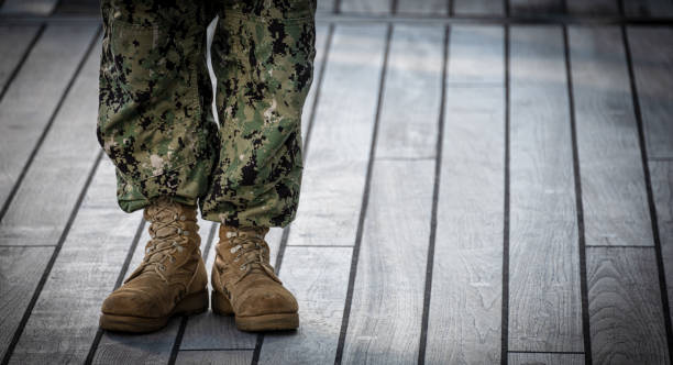 Military Boots and Camouflage Pants A soldier stands at the ready. military uniform stock pictures, royalty-free photos & images
