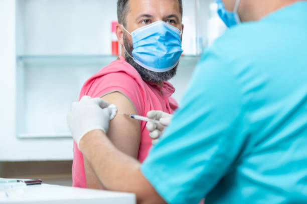 istock Patient with protective face mask looking at doctor after flu vaccination 1255423705