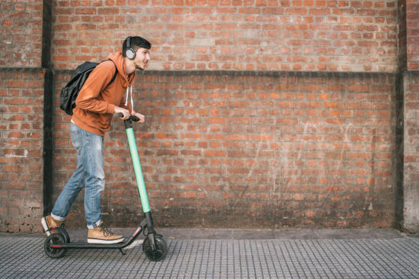 istock Young man driving electric scooter. 1255424862