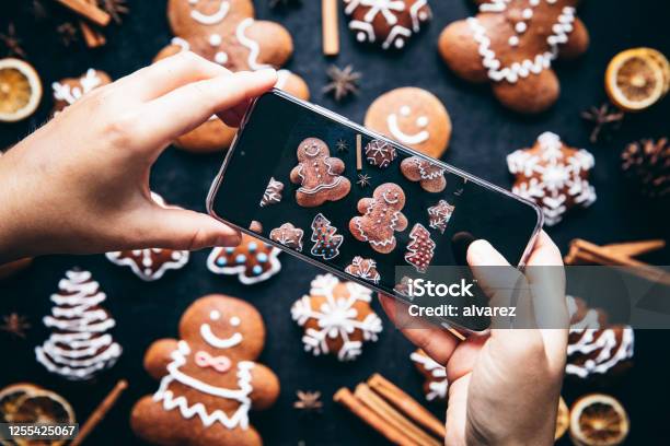 Vrouw Die De Peperkoekkoekjes Van Kerstmis Fotografeert Stockfoto en meer beelden van Kerstmis