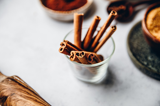Cinnamon sticks in a glass on kitchen counter. Traditional spices for making Christmas cookies.