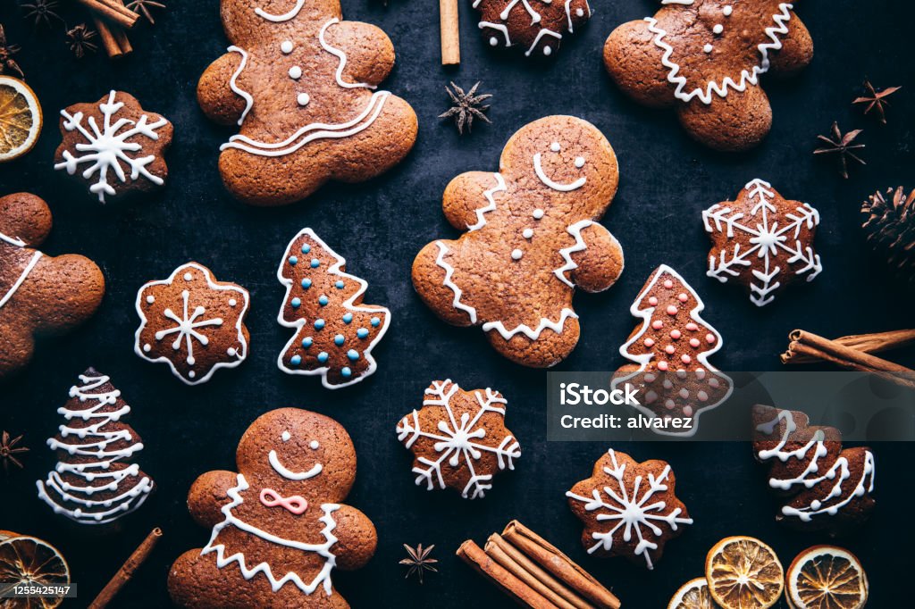 Christmas gingerbread man cookies and spices Directly above shot of decorated gingerbread cookies with spices on table. Homemade Christmas cookies on gray background. Christmas Stock Photo