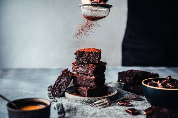 femmina che prepara brownies al cioccolato alle zucchine in cucina - muffin dolci foto e immagini stock