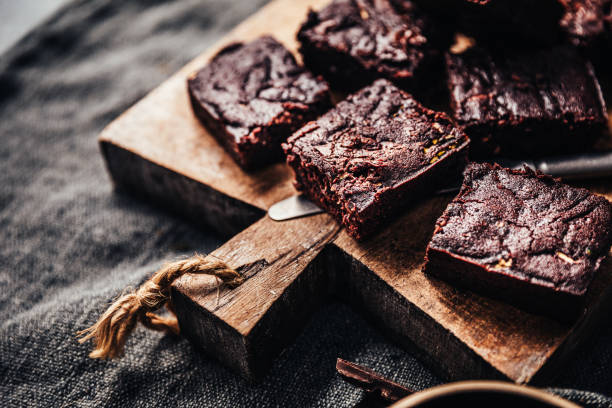 brownies di zucchine serviti su un piatto di legno - vegan food cake muffin chocolate foto e immagini stock