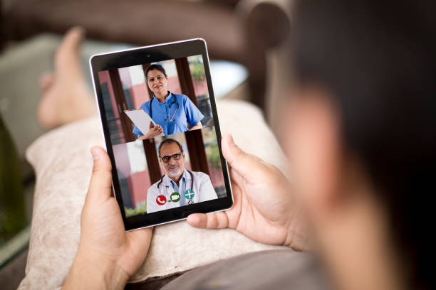 Man in video conference with doctor Sick man video conferencing with doctors using digital tablet Conference Calls Services stock pictures, royalty-free photos & images