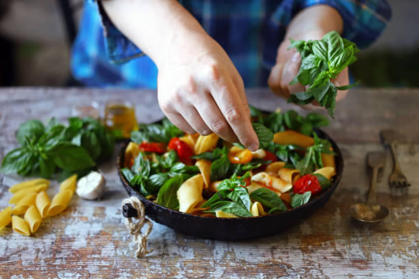 istock Hands of a chef with basil for cooking Italian pasta. 1255428546