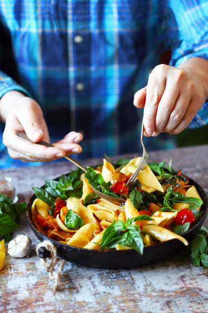 istock Hands of the chef mix the pasta in a pan. 1255428699