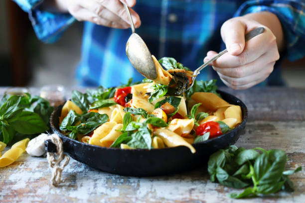 istock Hands of the chef mix the pasta in a pan. 1255428710