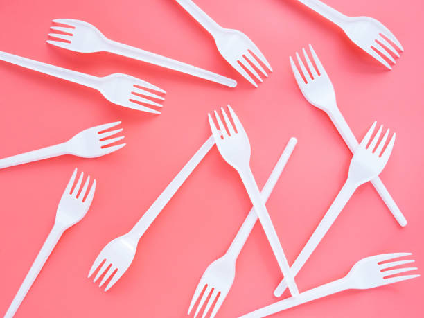istock Plastic white forks are scattered on a pink background, flat lay, top view. A bright modern concept of the problem of ecology. Non-degradable waste in nature is harmful to the planet 1255431779