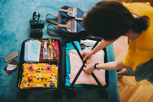 Mujer empacando maleta para viajar photo