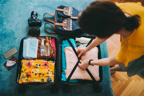 valise d’emballage de femme pour le voyage - empaqueter photos et images de collection