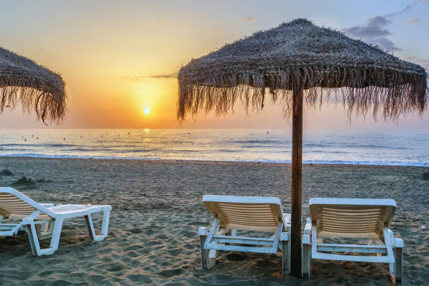 sunbed and umbrella on the sunset background, Torremolinos, Spain