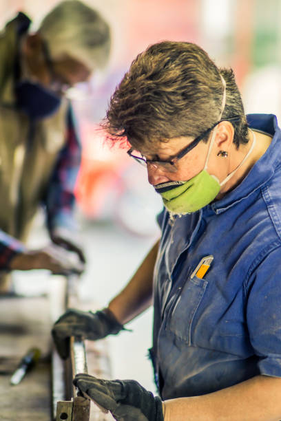 istock Female senior carpenter working on a wood plank 1255432085