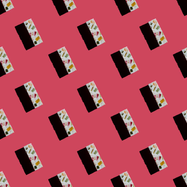 Bright minimalistic pattern. White marshmallow with hard shadows on a pink background, top view, flat lay, copy space. Creative sweet delicious concept. Ideas for packaging or wrapping paper.