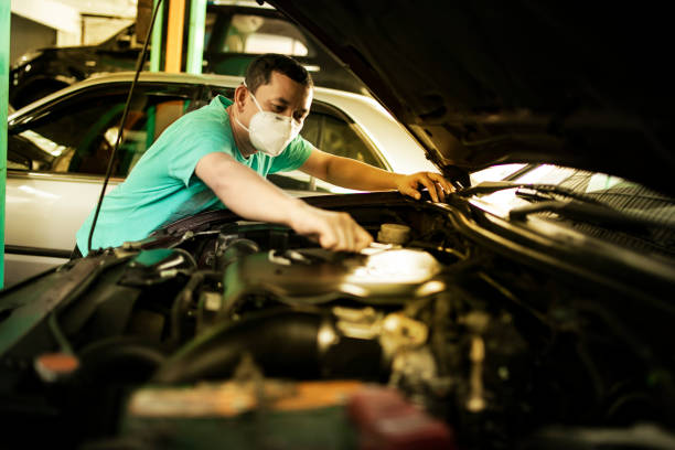 Engineer checking oil level in car service centre