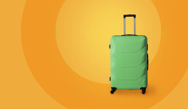 istock Travel luggage suitcase. Green plastic suitcase with wheels and retractable telescopic handle isolated on yellow background. Carry-on baggage. Vacation concept. Template blank for ad banner 1255434233