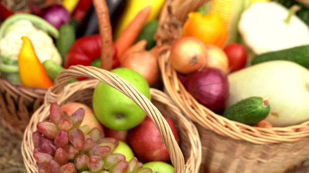 istock Summer fruits and vegetables in baskets. Abstract blurred image with apples, grapes, cauliflower, carrots, eggplant, peppers, onions, cucumbers, corn and zucchini in wicker baskets. Close-up shot 1255434315