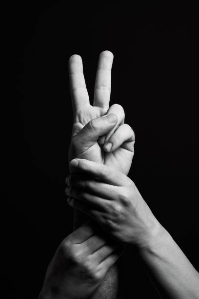 Protesting hand on black background Protesting hand on black background peace sign gesture photos stock pictures, royalty-free photos & images