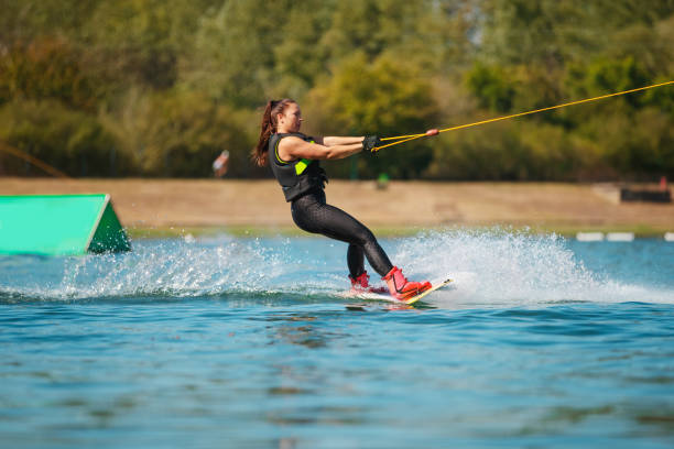istock Young woman on wakeboard reclining backwards 1255434522