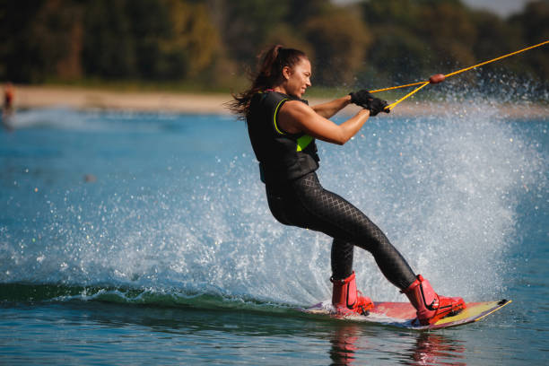 istock Young woman riding wakeboard reclined backwards 1255434538