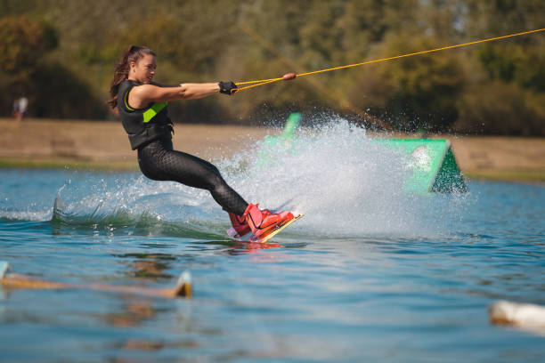 istock Young woman splashing with wakeboard on the lake 1255434583