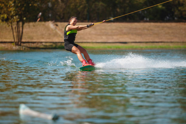 istock Young woman making a tilt backwards on wakeboard 1255434595