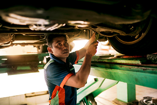 Professional mechanic repairing a car in auto repair shop