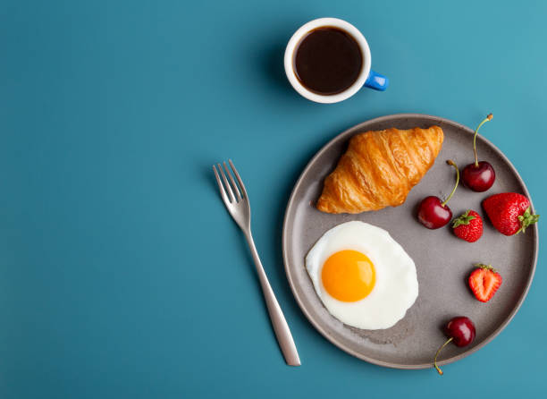 istock Minimal breakfast at blue background with coffee and croissant 1255435664