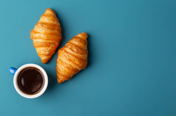 istock Horizontal copy space with two croissants and cup of fresh fragrant coffee at blue background 1255435691