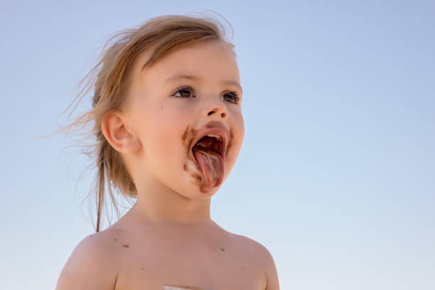 Happy child with strawberry near house in summer