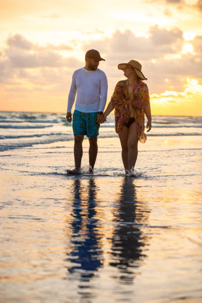 istock Latin couple walking on the beach 1255440047